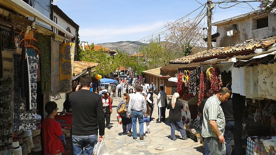 Şirince'nin dükkânlarla dolu dar sokağında ziyaretçi yoğunluğu.
